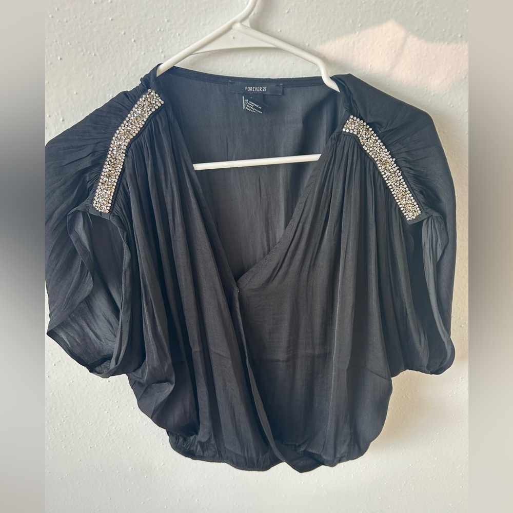 Silky black top with rhinestone shoulder detail